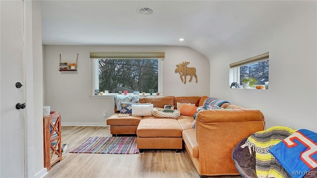 living area with plenty of natural light, visible vents, wood finished floors, and baseboards