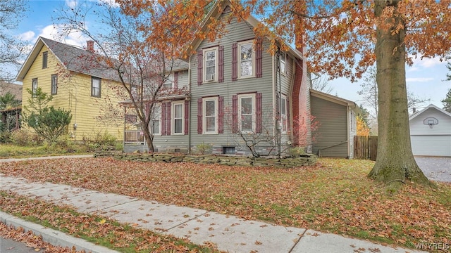 view of front facade featuring a chimney and a garage