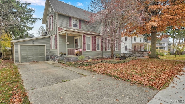 traditional home with a porch, an attached garage, a shingled roof, and driveway