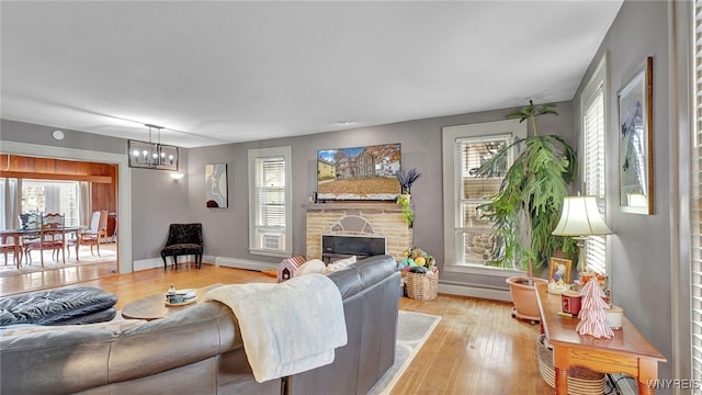 living area featuring a wealth of natural light, a chandelier, and baseboard heating