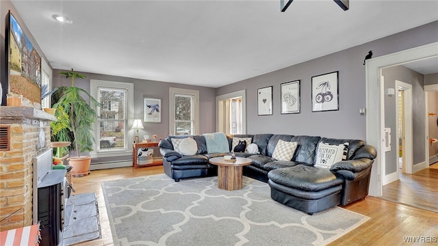 living room featuring baseboards, a baseboard radiator, and wood finished floors