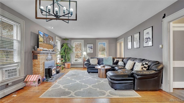 living room with an inviting chandelier, cooling unit, baseboard heating, and wood finished floors