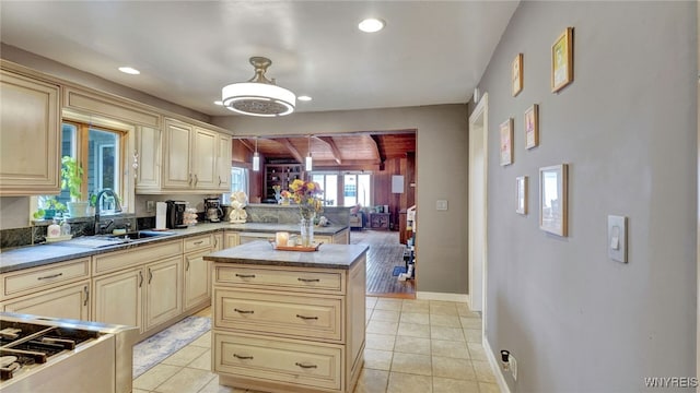 kitchen with cream cabinets, light tile patterned flooring, a sink, and recessed lighting