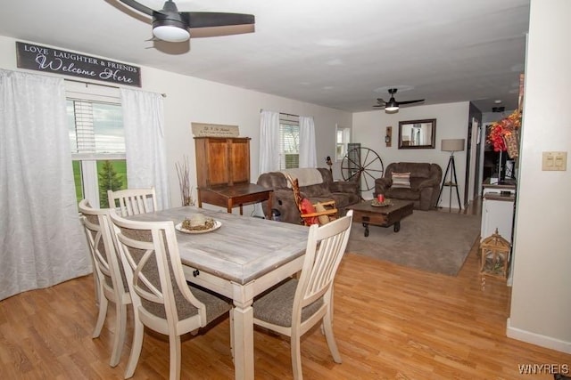 dining space with light wood finished floors and ceiling fan