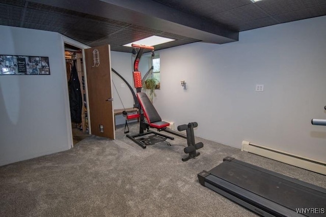 workout area featuring a baseboard heating unit and carpet