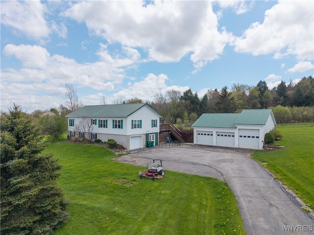 view of front of property with stairway, a front yard, a detached garage, and asphalt driveway