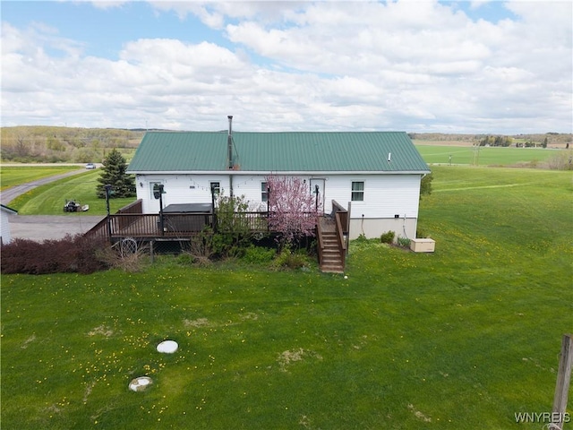 back of house featuring a deck, a yard, metal roof, and stairway