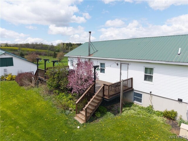 rear view of house featuring a yard and metal roof