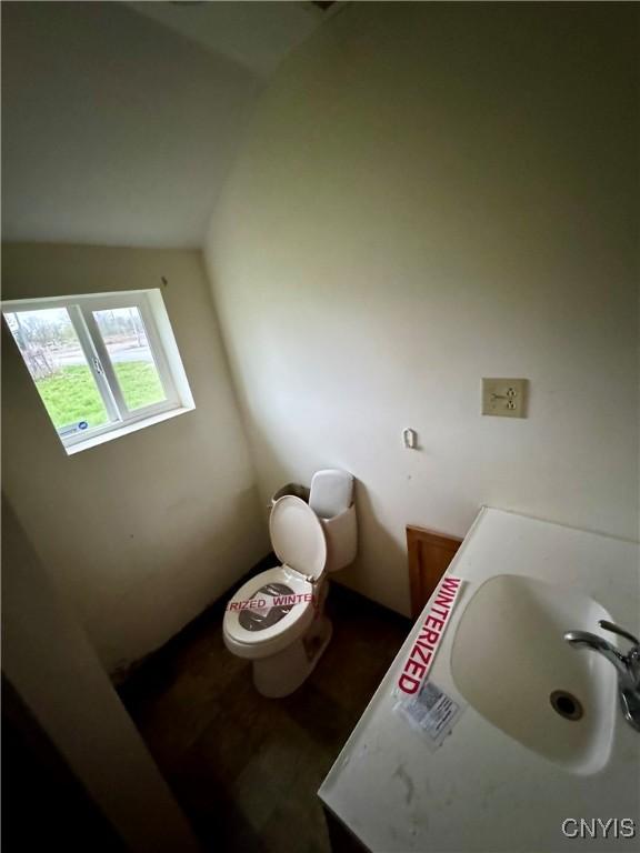 32 Spencer St, Gouverneur, NY 13642 - bathroom with vaulted ceiling, toilet, and a sink