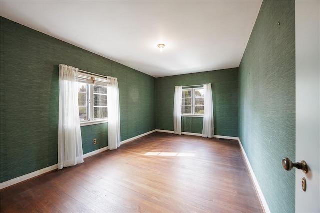 spare room featuring wood finished floors and baseboards