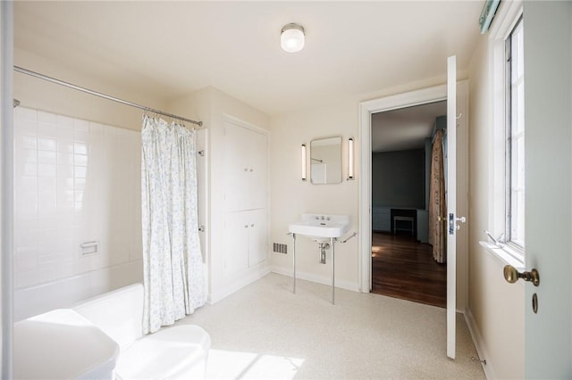 full bathroom featuring baseboards and shower / bath combo with shower curtain