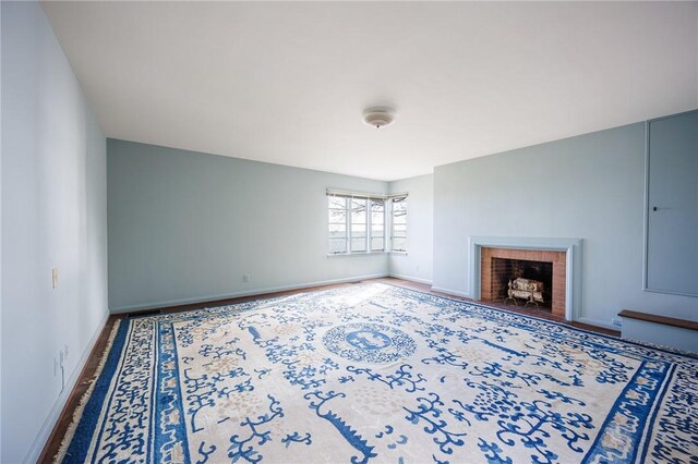 unfurnished living room with a fireplace and baseboards