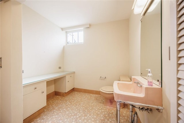 bathroom with toilet and baseboards