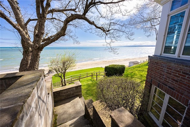 water view featuring nearby beach and fence