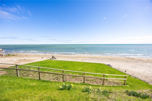 water view featuring local beach and fence