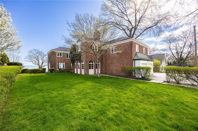 rear view of property featuring brick siding and a lawn
