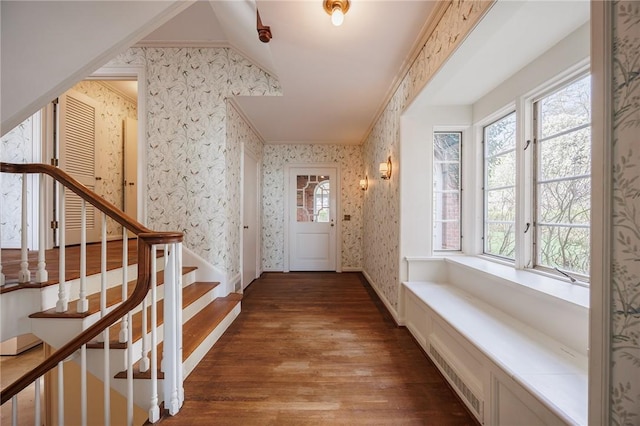 hallway featuring wallpapered walls, wood finished floors, and stairway