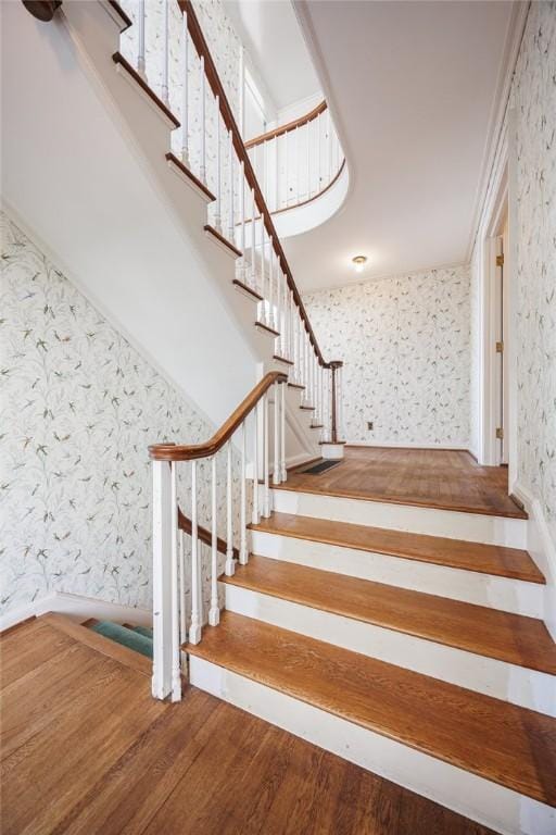 stairs featuring wallpapered walls and wood finished floors