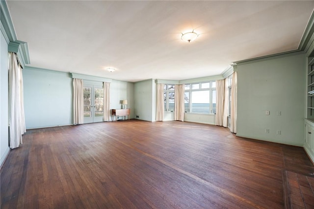 unfurnished living room with healthy amount of natural light, dark wood-style floors, ornamental molding, and baseboards