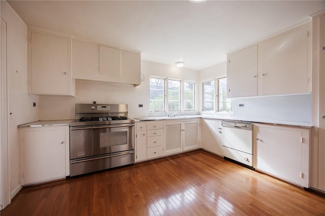 kitchen with range with two ovens, white dishwasher, hardwood / wood-style floors, light countertops, and white cabinetry