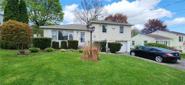 split level home with asphalt driveway, an attached garage, and a front lawn