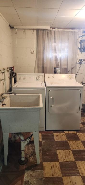 laundry room featuring independent washer and dryer and concrete block wall