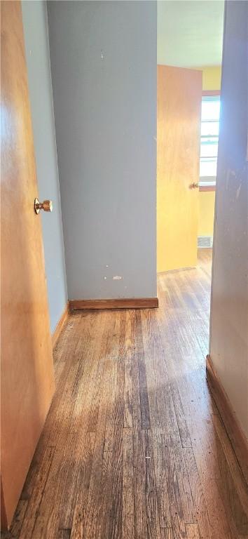 spare room featuring wood finished floors and baseboards