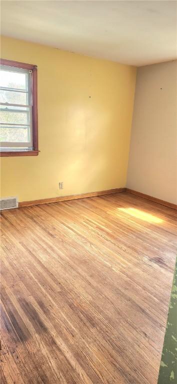spare room featuring wood finished floors and baseboards