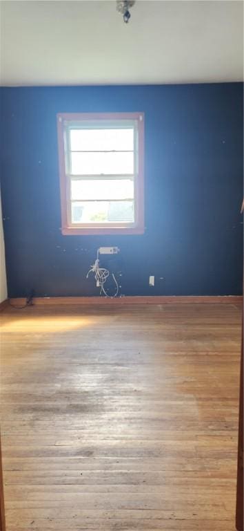 empty room featuring wood finished floors and baseboards