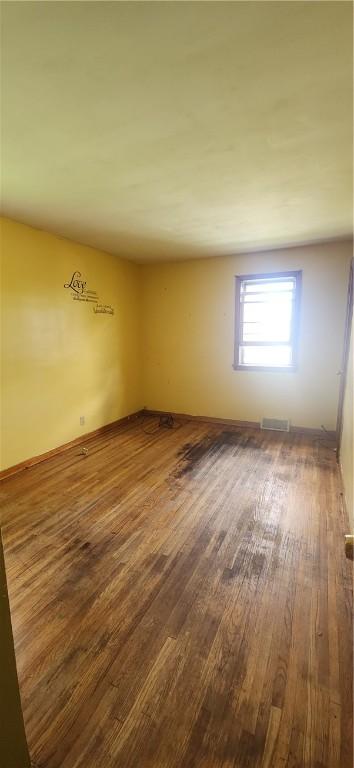 empty room featuring wood finished floors and baseboards