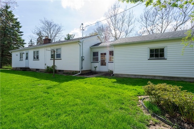 back of house featuring a lawn and a chimney