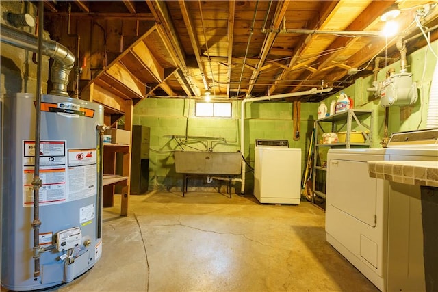 basement with water heater, washing machine and dryer, and a sink