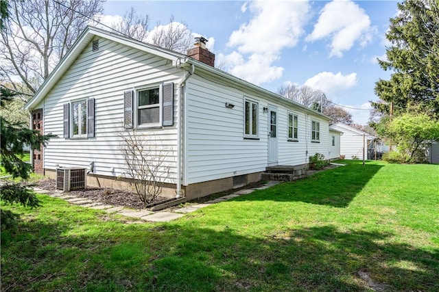 view of home's exterior featuring a chimney, central AC unit, and a lawn