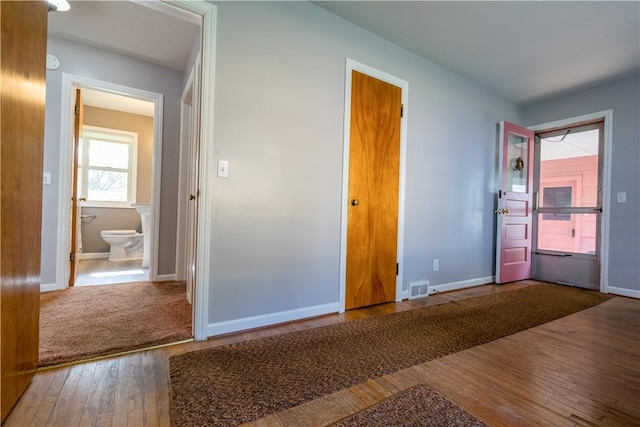 unfurnished bedroom featuring wood-type flooring and baseboards