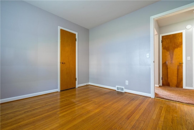 empty room with wood finished floors and baseboards