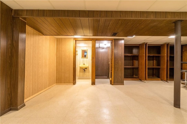 finished basement with wood walls and tile patterned floors