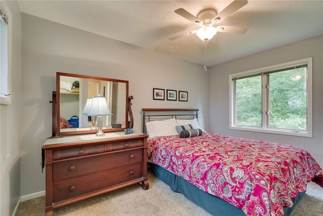 carpeted bedroom with ceiling fan and baseboards