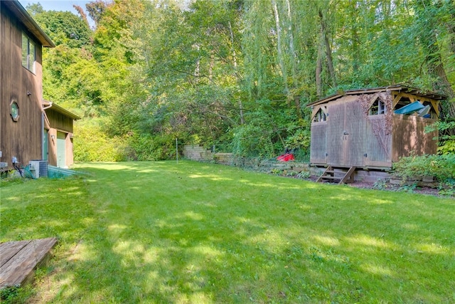 view of green lawn with a wooded view and a garage
