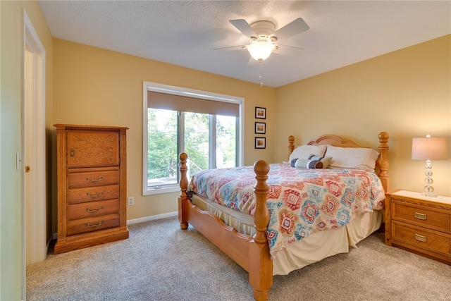 bedroom with light colored carpet, ceiling fan, and baseboards