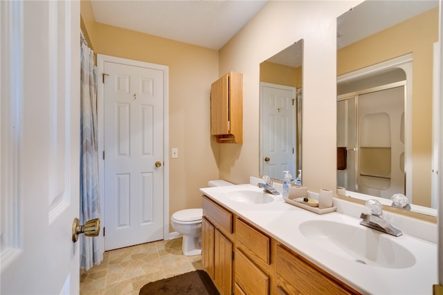 bathroom with a shower with shower curtain, toilet, and double vanity