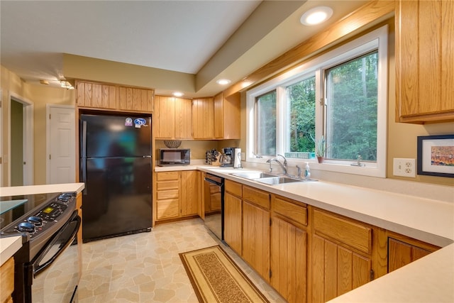 kitchen featuring black appliances, a sink, healthy amount of natural light, light countertops, and recessed lighting