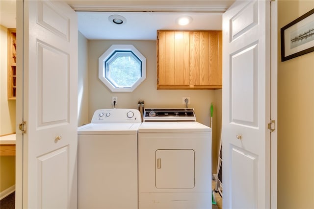 clothes washing area with cabinet space and washing machine and dryer