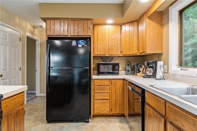 kitchen with black appliances, light countertops, and brown cabinetry