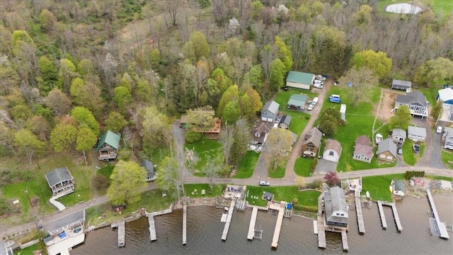 aerial view of property's location featuring a nearby body of water and a forest