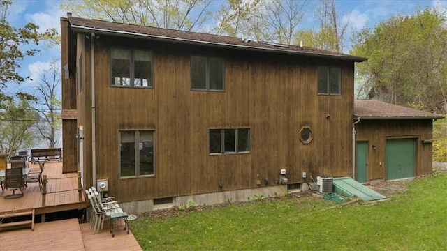 rear view of property with a wooden deck, a yard, central AC, and roof with shingles