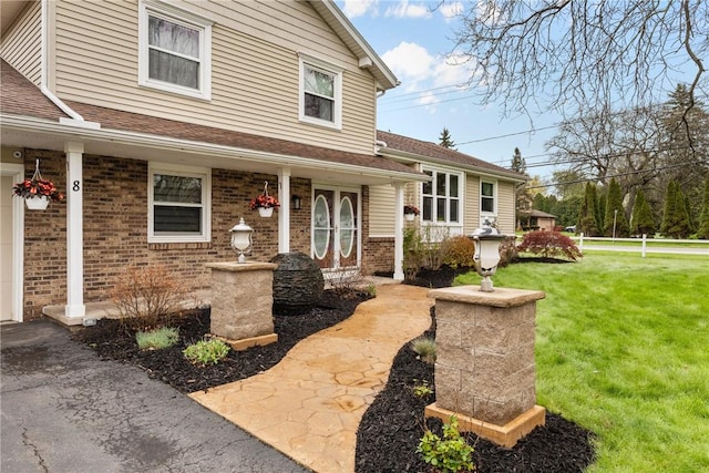 view of front facade featuring a front lawn, brick siding, and a shingled roof