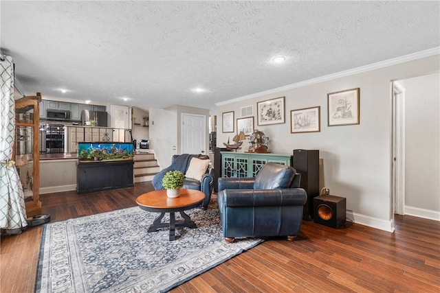 living room featuring a textured ceiling, hardwood / wood-style flooring, ornamental molding, baseboards, and stairs