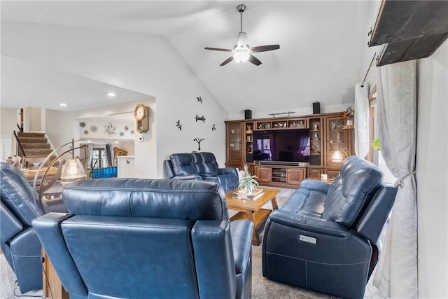 living area with vaulted ceiling, ceiling fan, and stairway