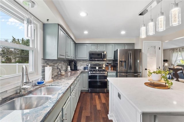 kitchen with stainless steel appliances, a sink, gray cabinetry, dark wood-style floors, and recessed lighting