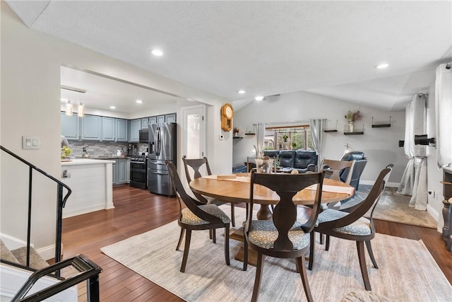 dining area featuring dark wood-type flooring, vaulted ceiling, baseboards, and recessed lighting